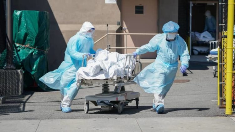 (FILES) In this file photo taken on April 06, 2020 bodies are moved to a refrigeration truck serving as a temporary morgue at Wyckoff Hospital in the Borough of Brooklyn in New York. - The global coronavirus pandemic has sparked an economic "crisis like no other," sending world GDP plunging 4.9 percent this year and wiping out $12 trillion over two years, the IMF said June 24, 2020. Worldwide business shutdowns destroyed hundreds of millions of jobs, and major economies in Europe face double-digit collapses.The prospects for recovery post-pandemic -- like the forecasts themselves -- are steeped in "pervasive uncertainty" given the unpredictable path of the virus, the IMF said in its updated World Economic Outlook. (Photo by Bryan R. Smith / AFP)